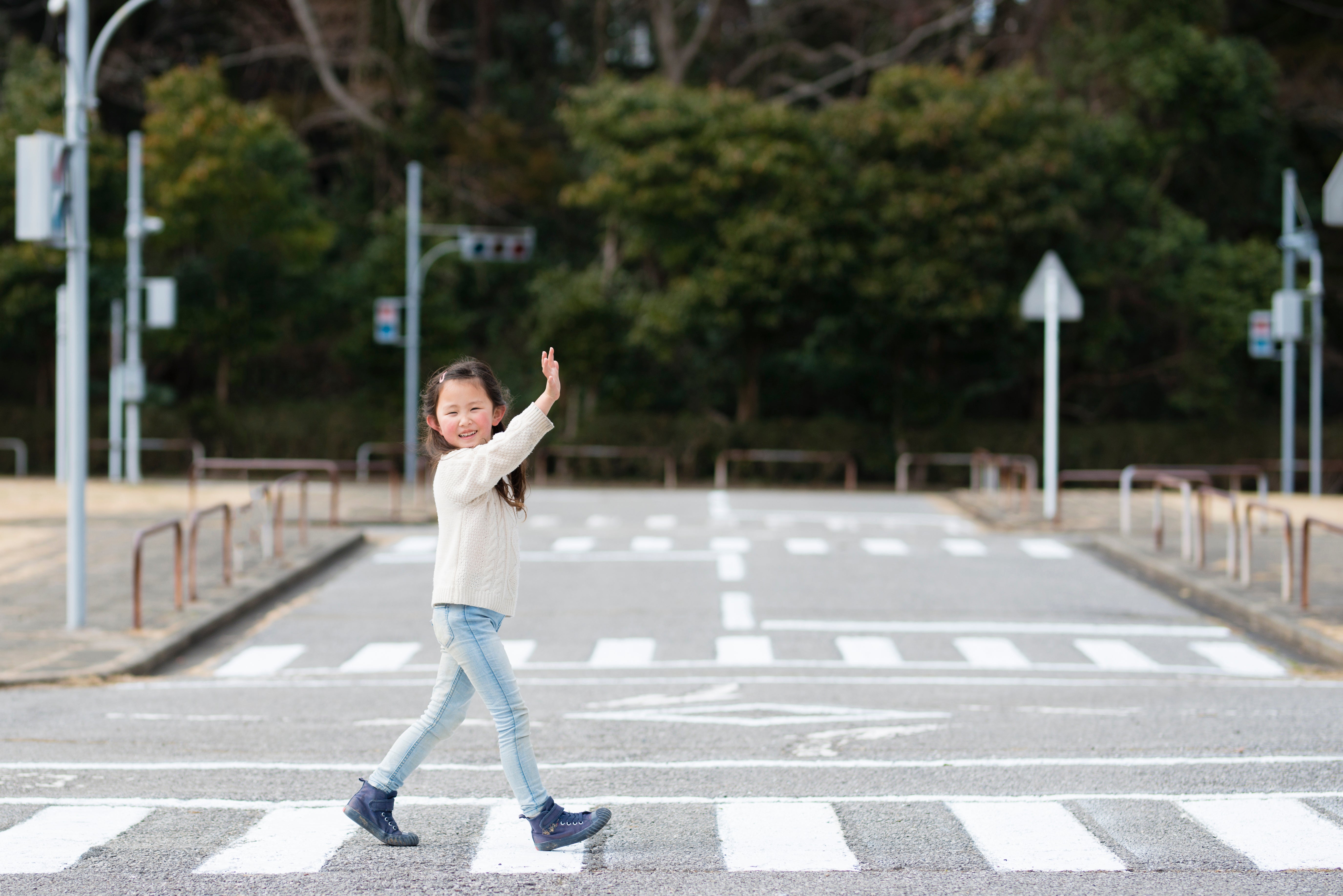 手を挙げて横断歩道を渡る子供