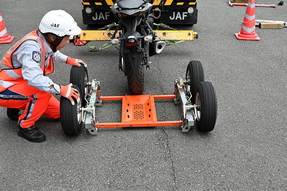 後輪を載せるバケットに小径タイヤを取り付け、後輪をバケットへ載せていく