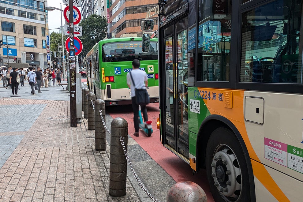 前後の車の間に入っていく電動キックボード