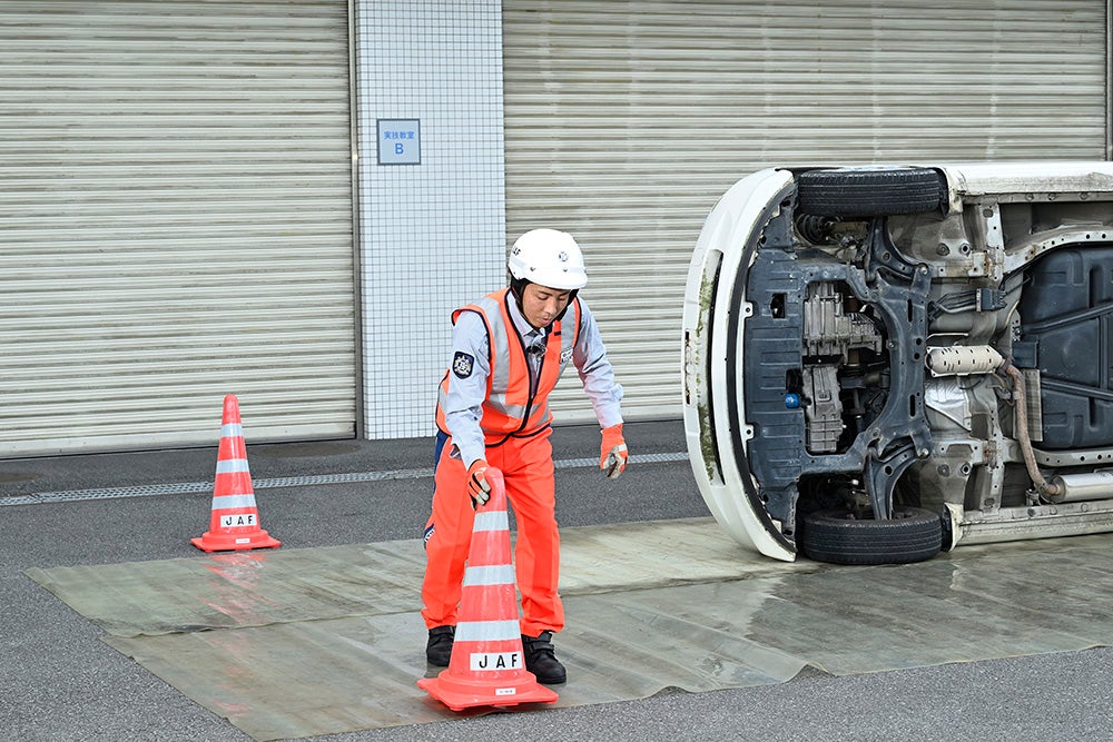 安全確保のためのパイロンを設置、泥でぬかるんだ道での作業では特に重要