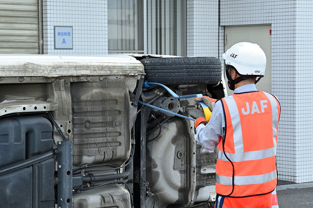 作業に適した頑丈な部分を見極め、被災車に2本のベルトを通す