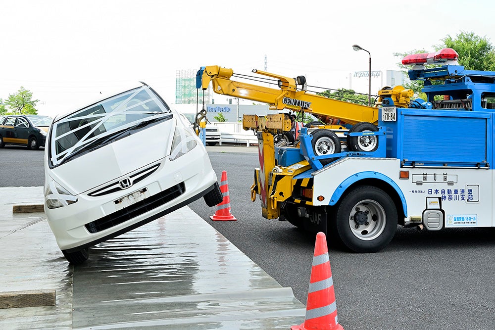 被災車のダメージが増えないよう4輪が接地するまで注意深く下ろす