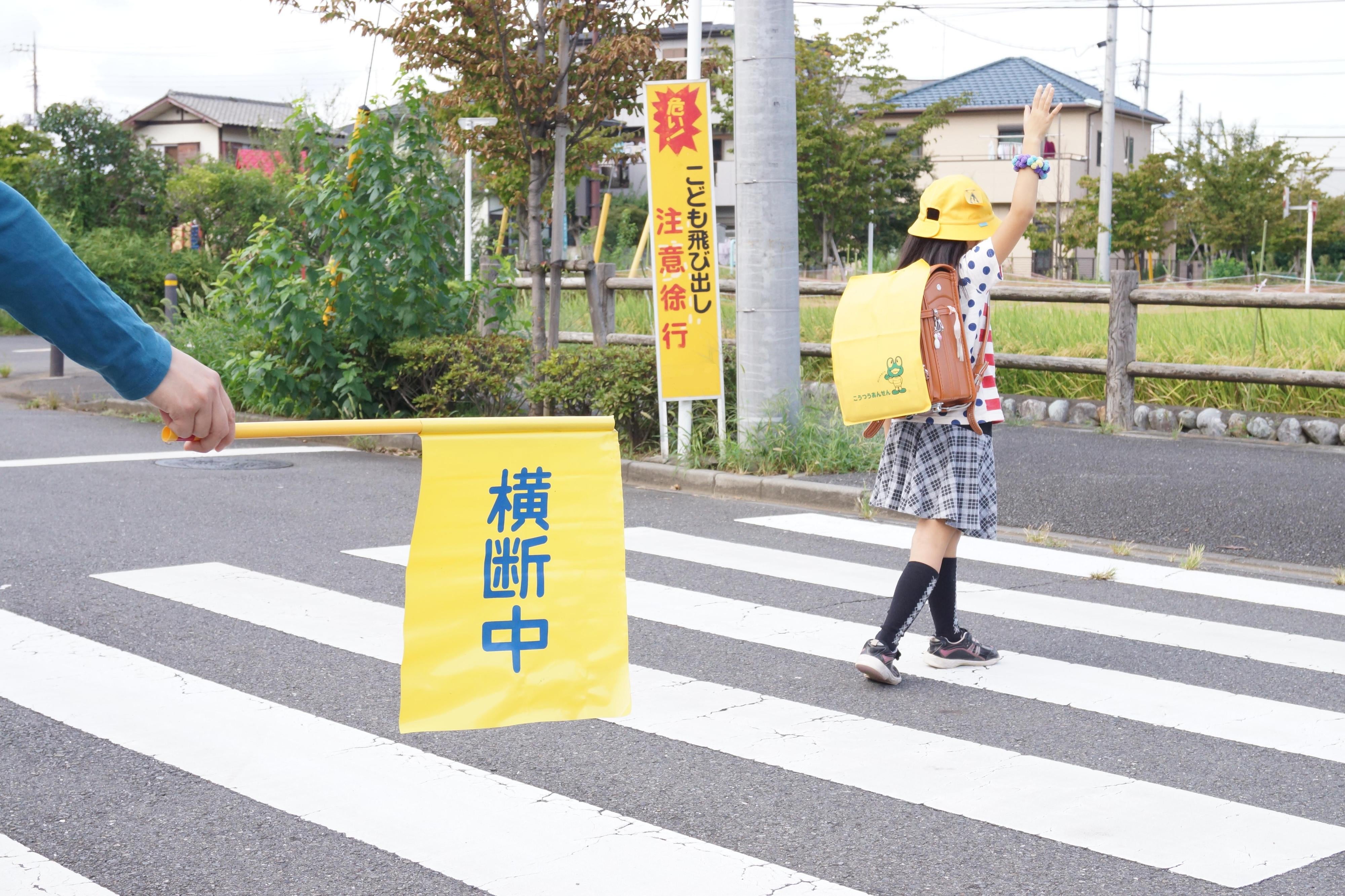 手を挙げて横断歩道を渡る子ども