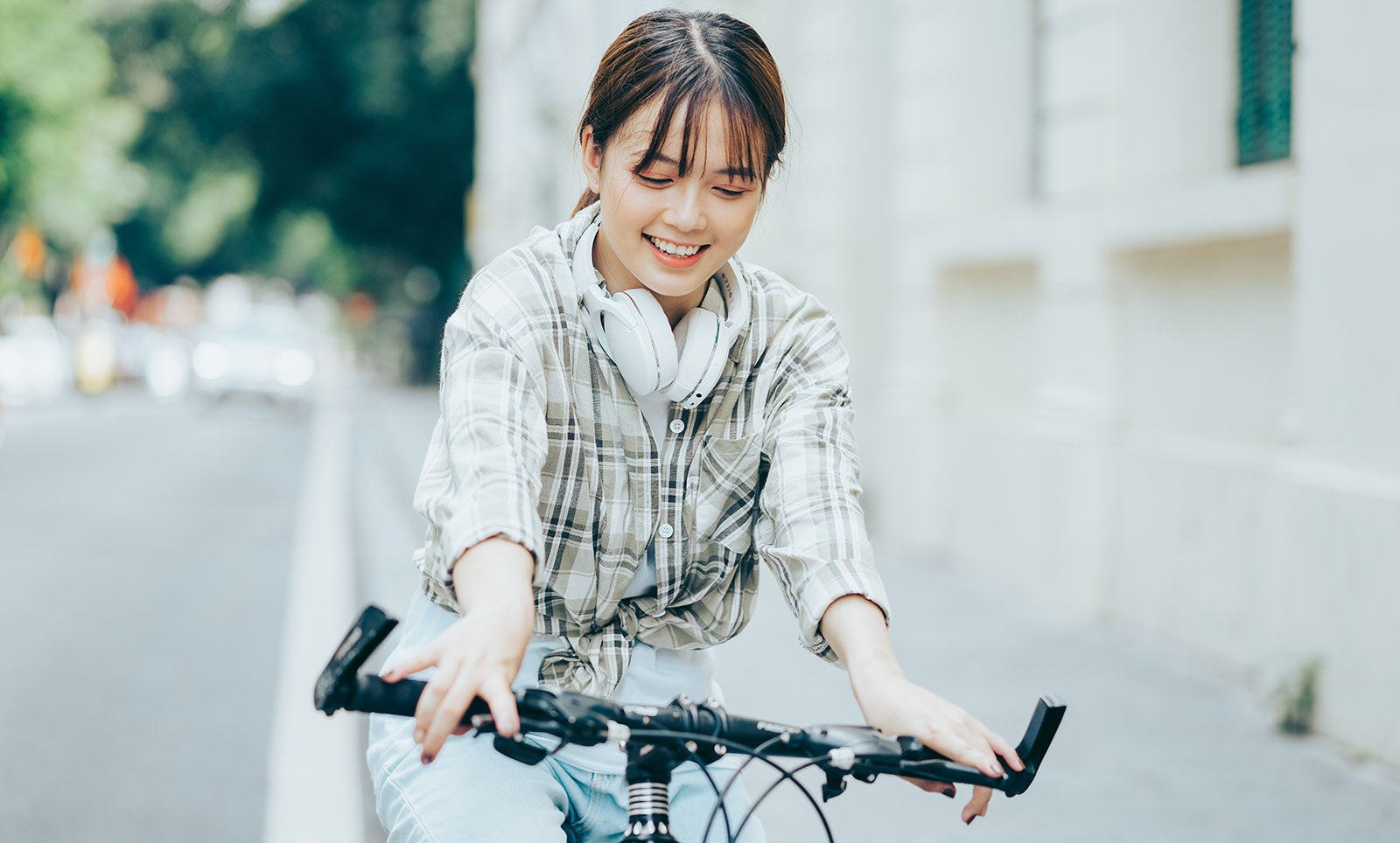 イヤホンをして自転車を運転する女性