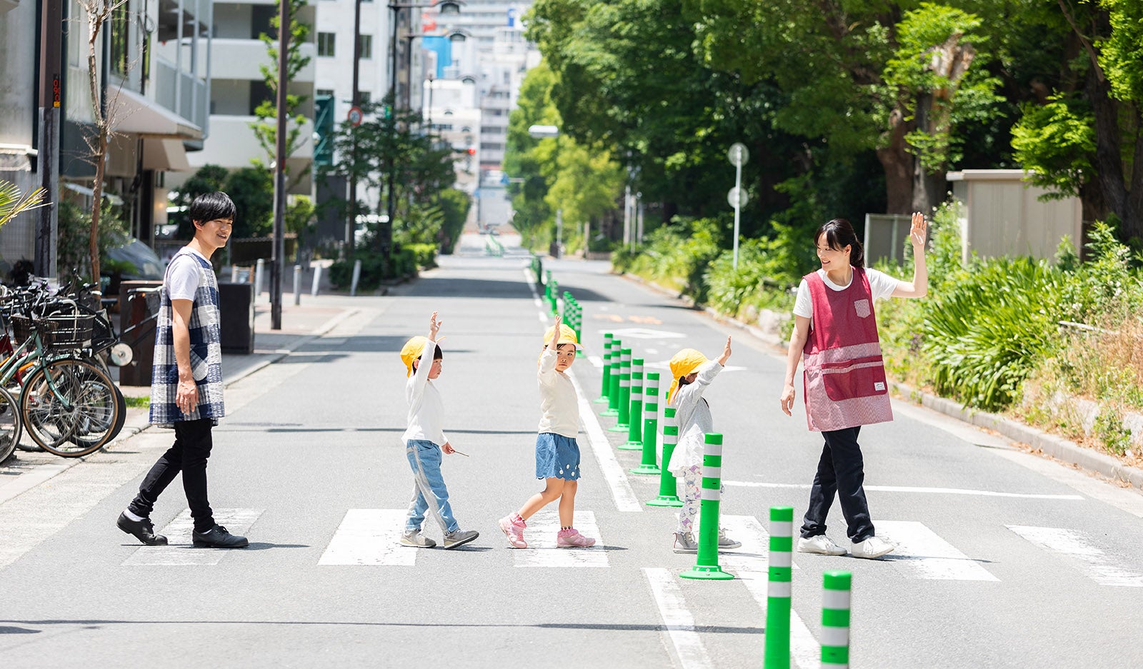 手を挙げて横断歩道を渡る子供たち