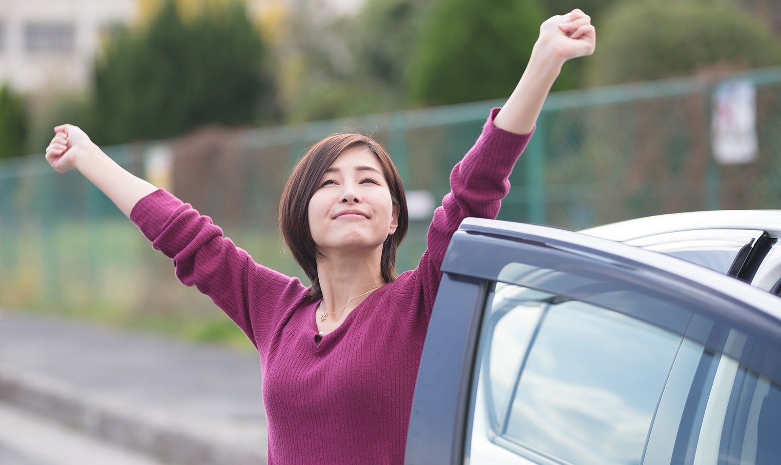 長時間の運転で緊張した筋肉をほぐす女性