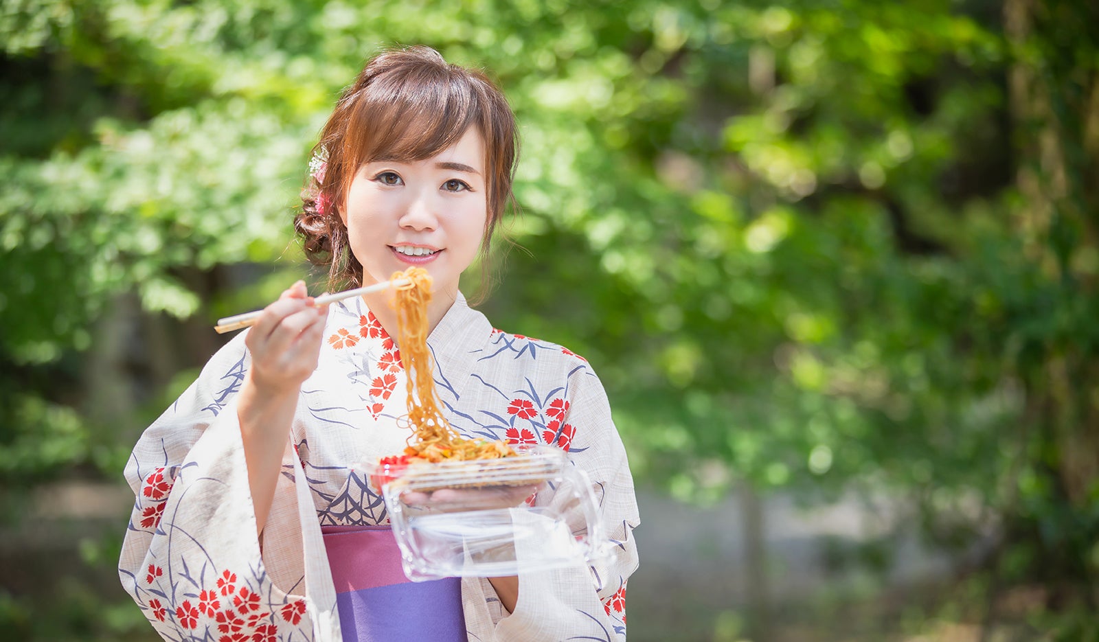 ご当地グルメの焼きそばを食べる女性