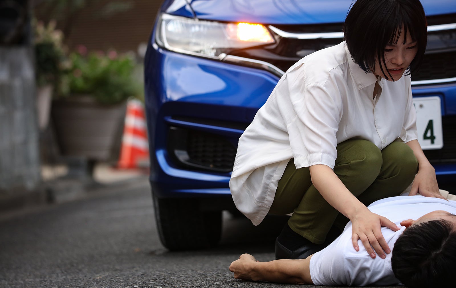 人事事故で負傷者を救助する女性ドライバーのイメージ