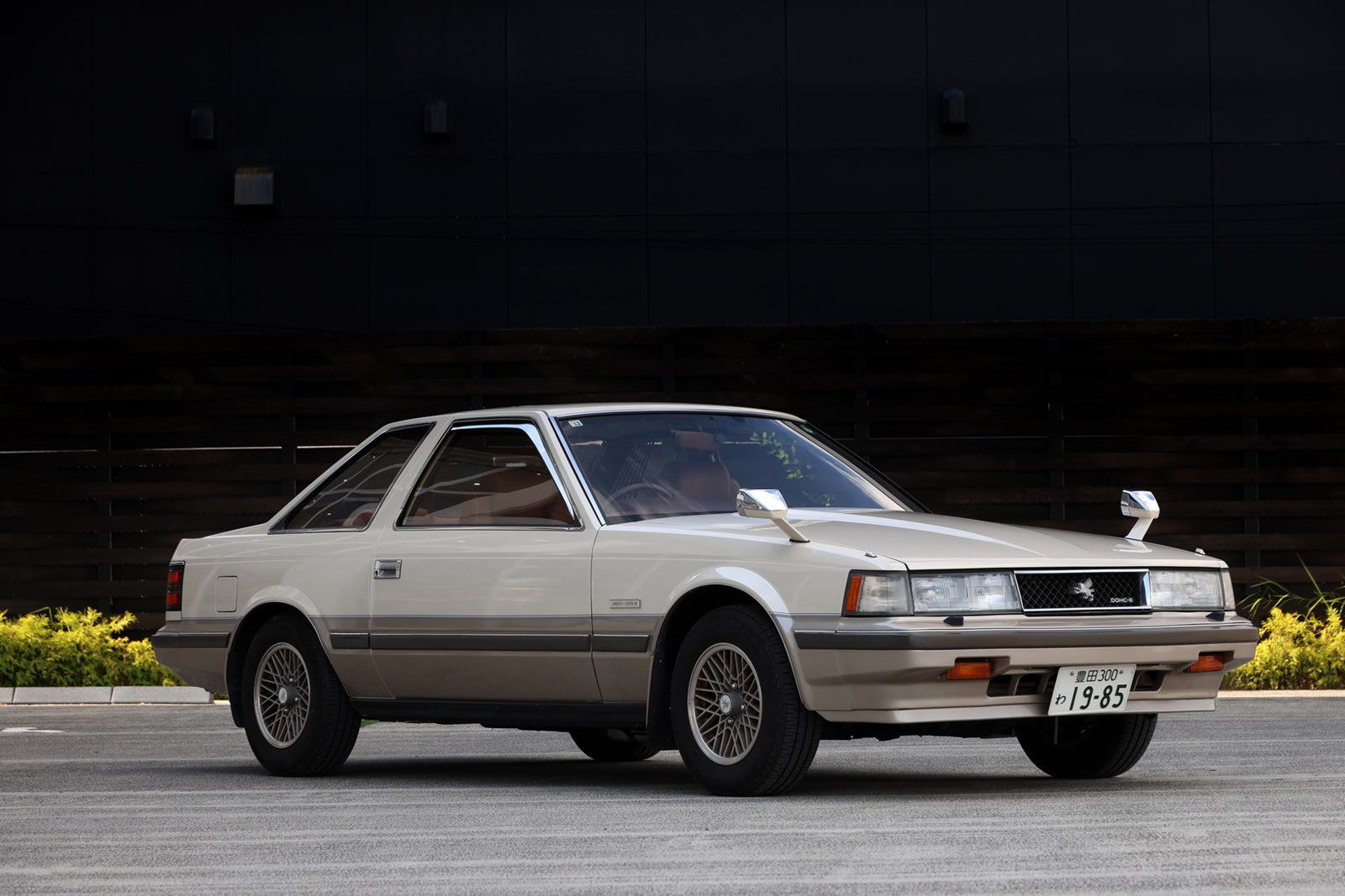 ベージュのツートンカラーの初代ソアラ。前面に『SOARER』のエンブレムと日本のナンバープレート『19-85』が付いている