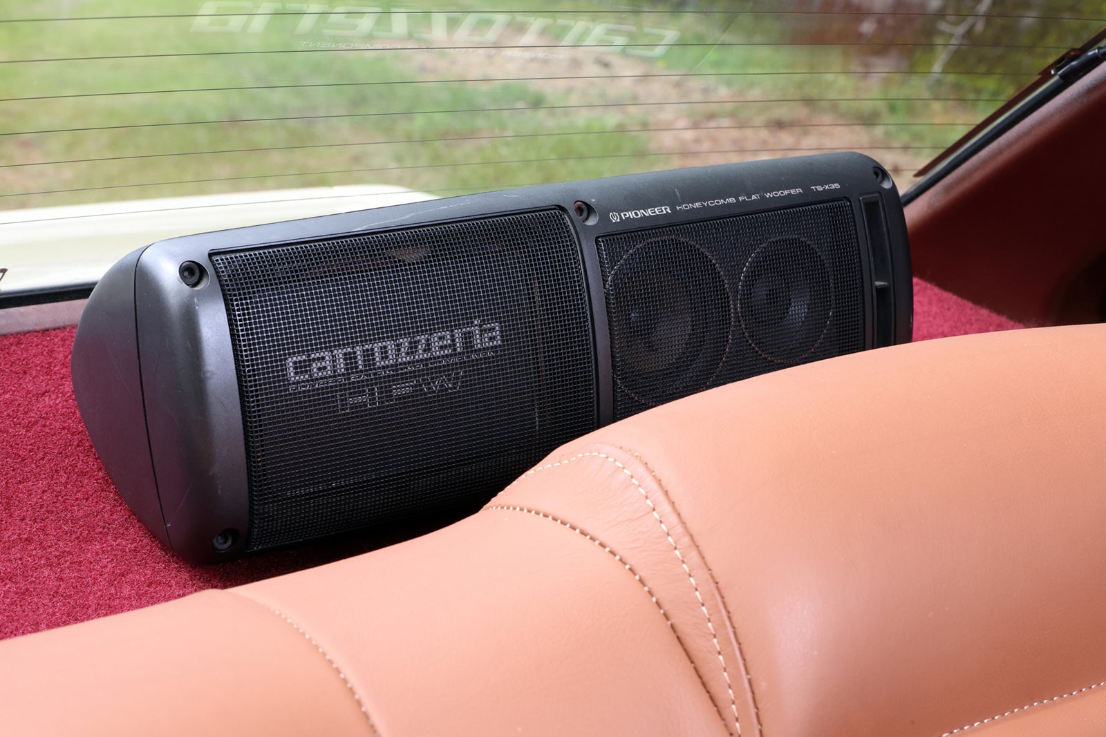 初代トヨタ・ソアラのリアトレイに設置されたPioneer carrozzeriaスピーカー。赤いカーペットと茶色のシートが映える