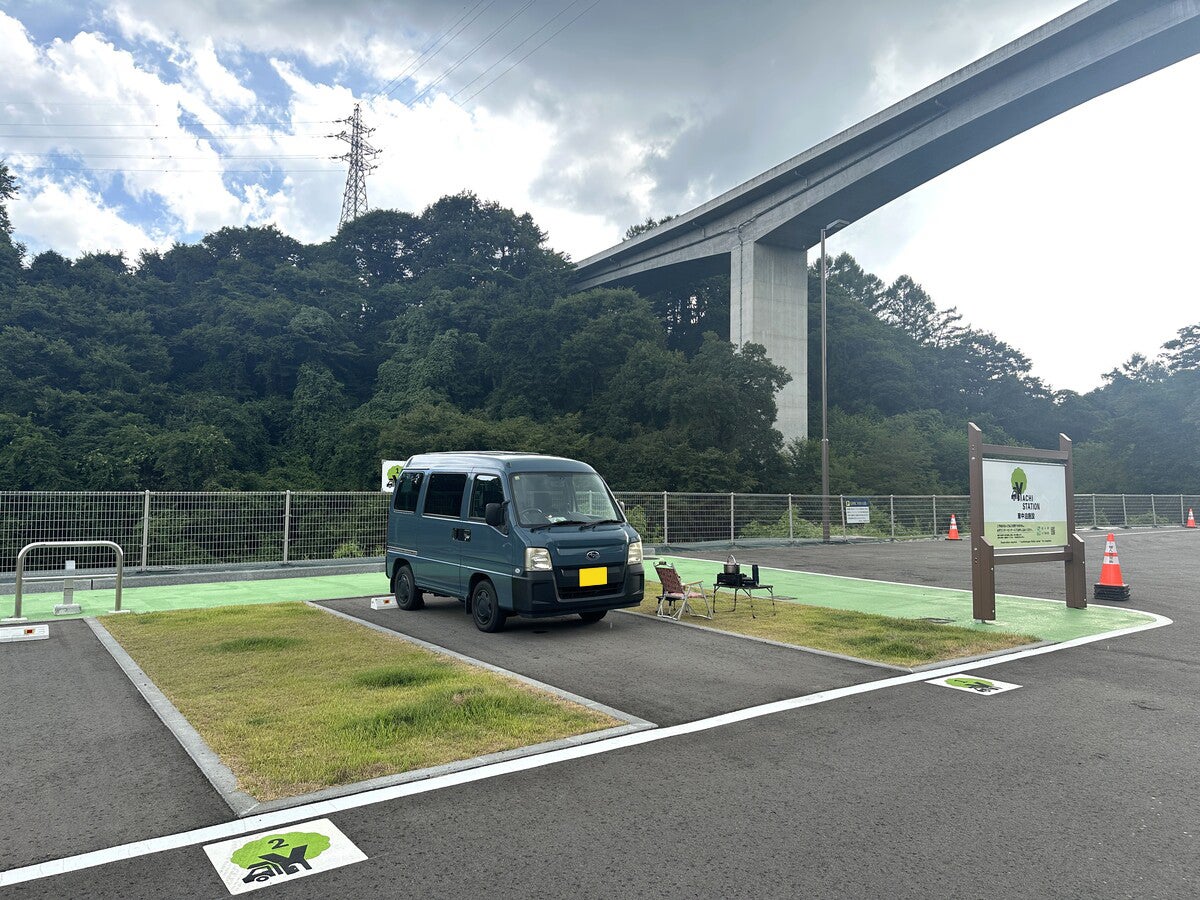 車中泊エリアに駐車している軽バン、テーブルと椅子を出している
