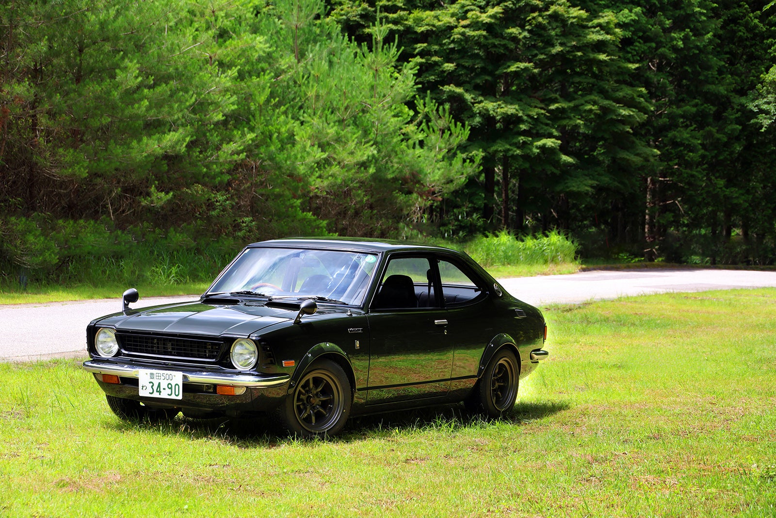 森林道路脇の草地に停車する1974年式トヨタ・カローラレビンTE27型モスグリーン。旧車レンタル・クラシックカー