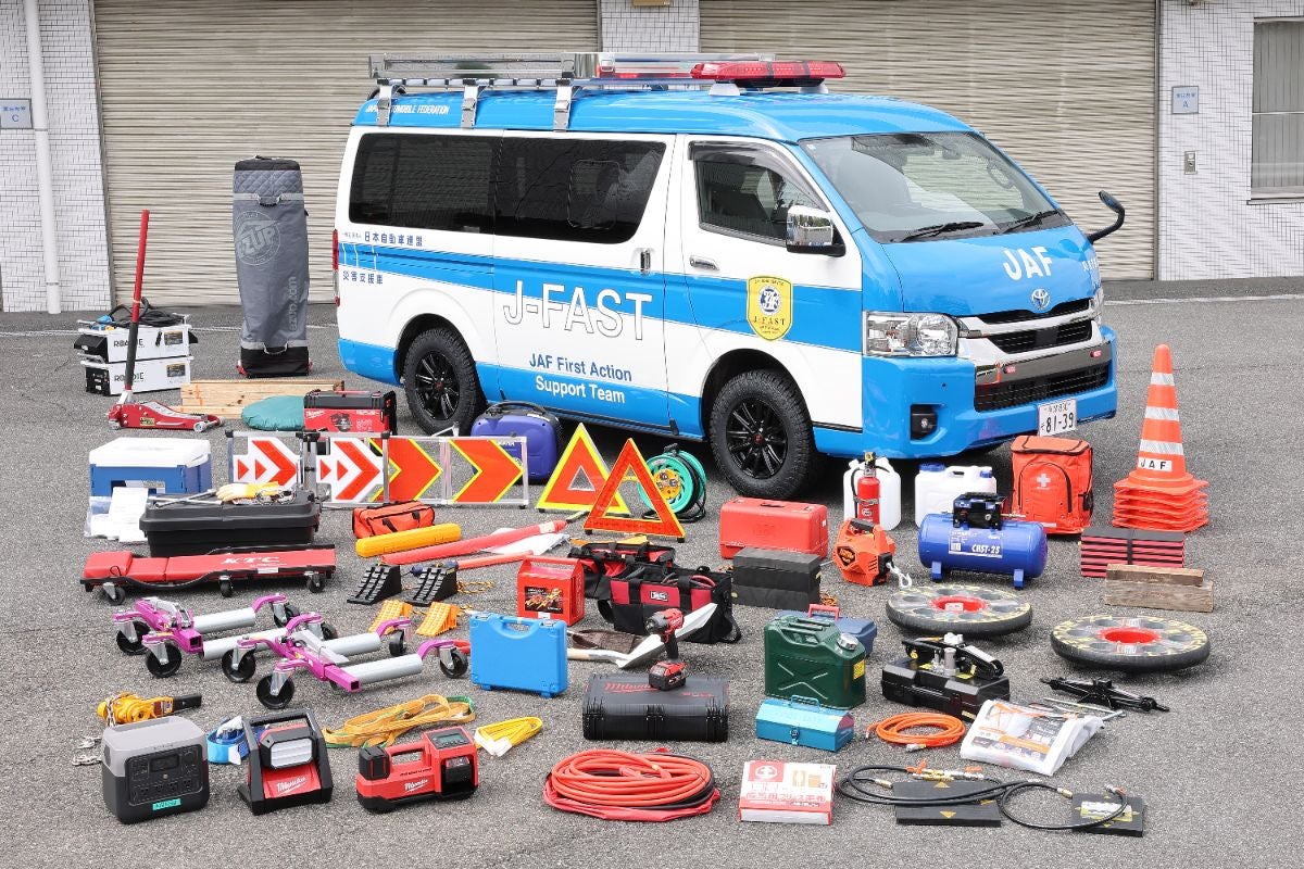 J-FAST災害支援車の前に、発電機、照明器具、標識、コーン、救援用工具、ケーブルなど多種多様な災害対応資機材が並べられている