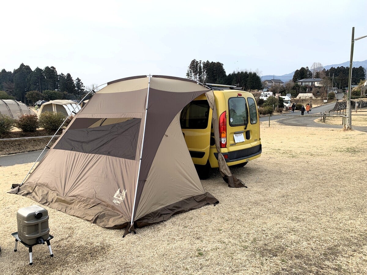 キャンプ場でカーサイドタープを装着した黄色いクルマ