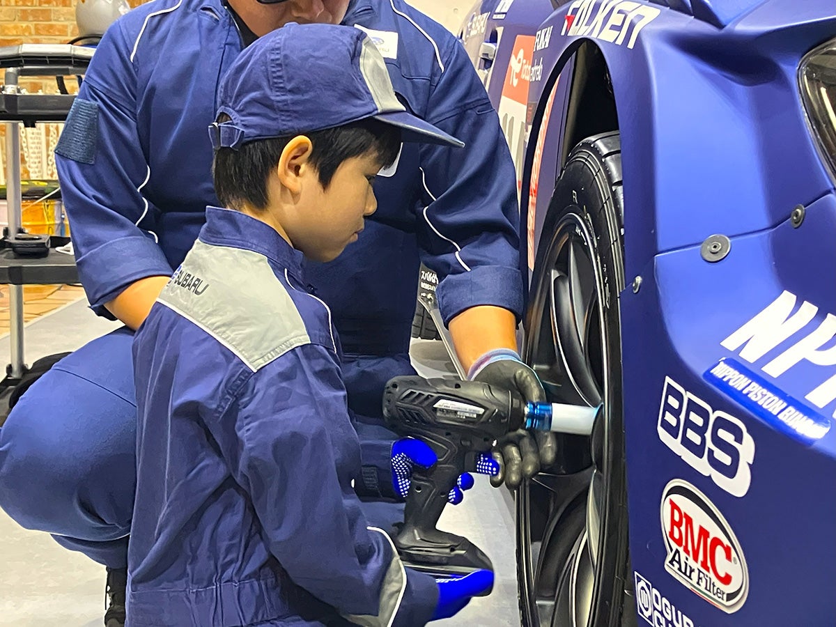 SUBARUのレーシングメカニック体験でタイヤ交換をする子ども