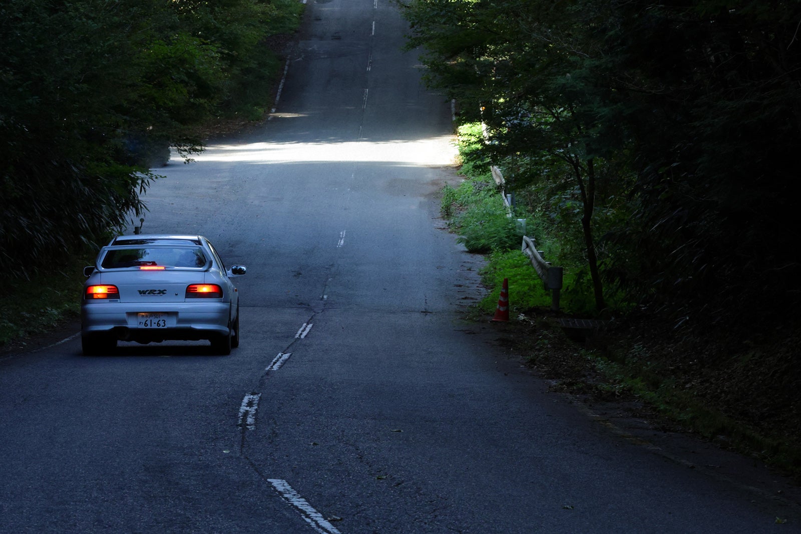 インプレッサWRX STi バージョンVが山道を走り去る後ろ姿、リアウイングが際立つ