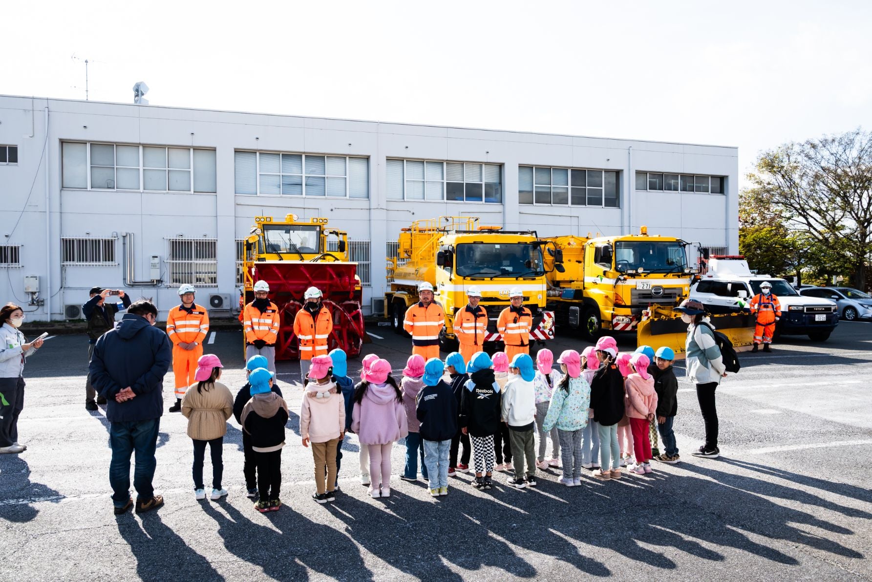 高速道路の安全祈願・出陣式で、除雪トラックや湿塩散布車を見学する幼稚園児たち。