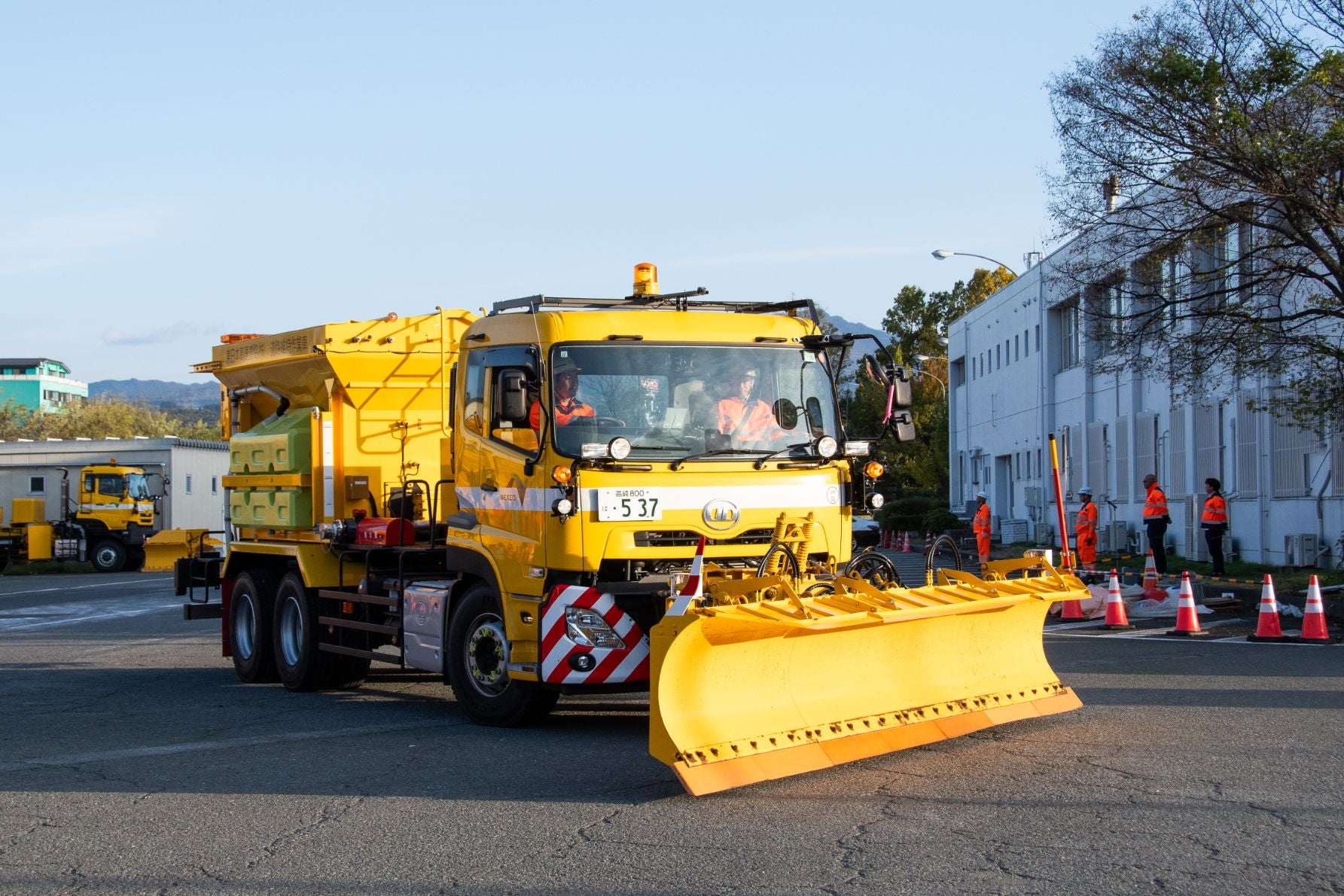 除雪作業中に湿った塩と塩水を散布する湿塩散布車。前方にプラウを展開している。