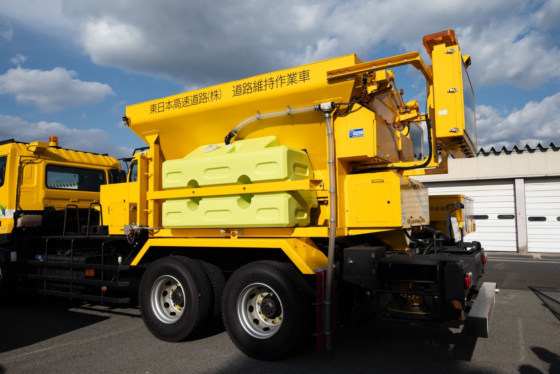 湿塩散布車の車体に搭載された、凍結防止剤を蓄える大型ホッパー（タンク）。