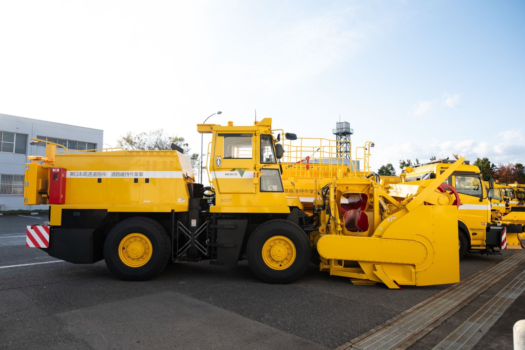 車体中央部が折れて操舵する（アーティキュレート式）構造のロータリー除雪車の側面。PTOでオーガを駆動させている