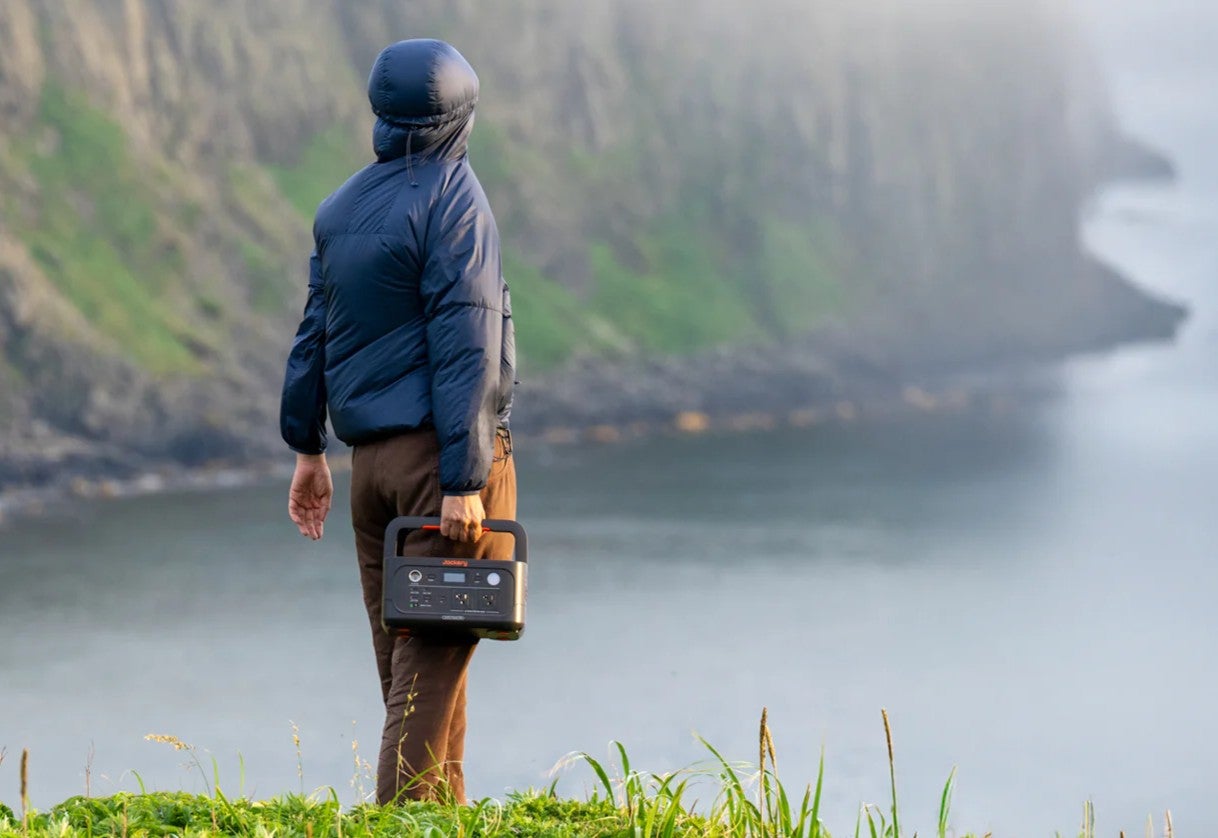 山で小型ポータブル電源を持つ男性の後ろ姿