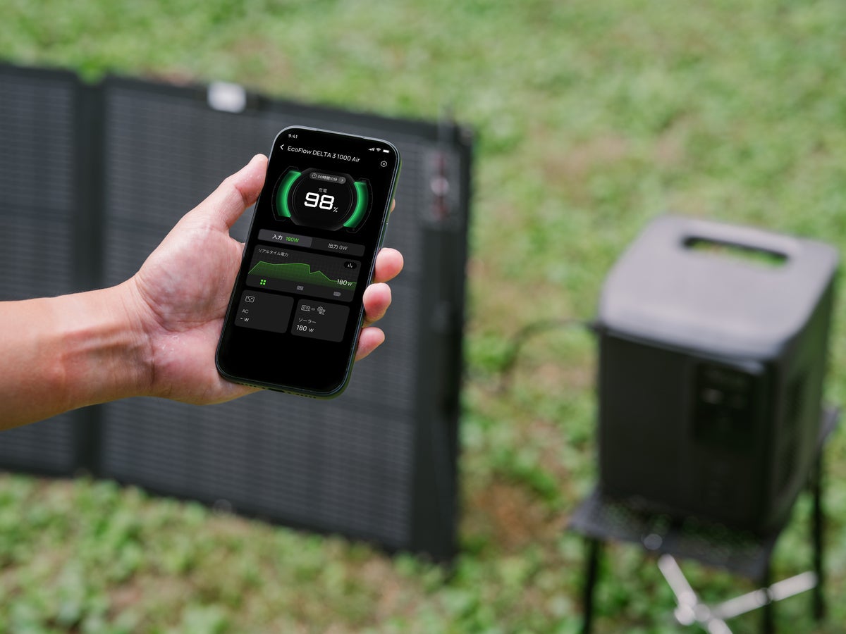 ポータブル電源をバックにスマホのアプリを表示している写真