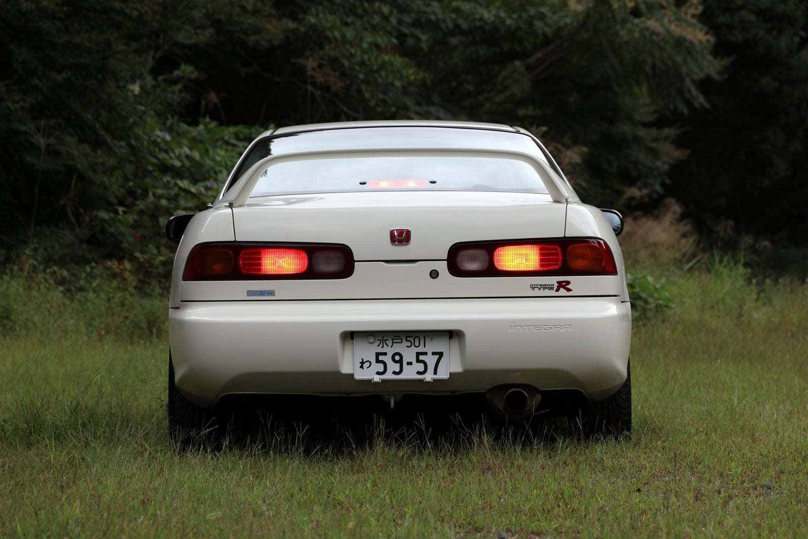インテグラ タイプRのリア全体像。特徴的な大型リアスポイラー、赤バッジ、テールランプが点灯している