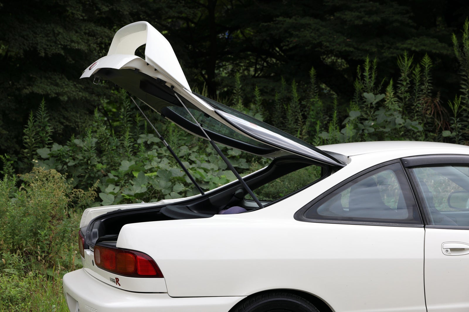 リアハッチ（トランク）を全開にした状態のインテグラ タイプRを横から撮影。大きな開口部と高いリアウイングが特徴的