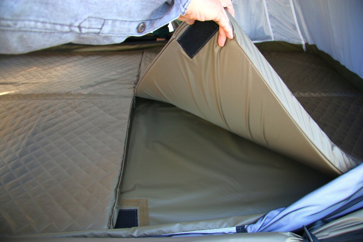 ルーフトップテント床面のマットをめくっている写真