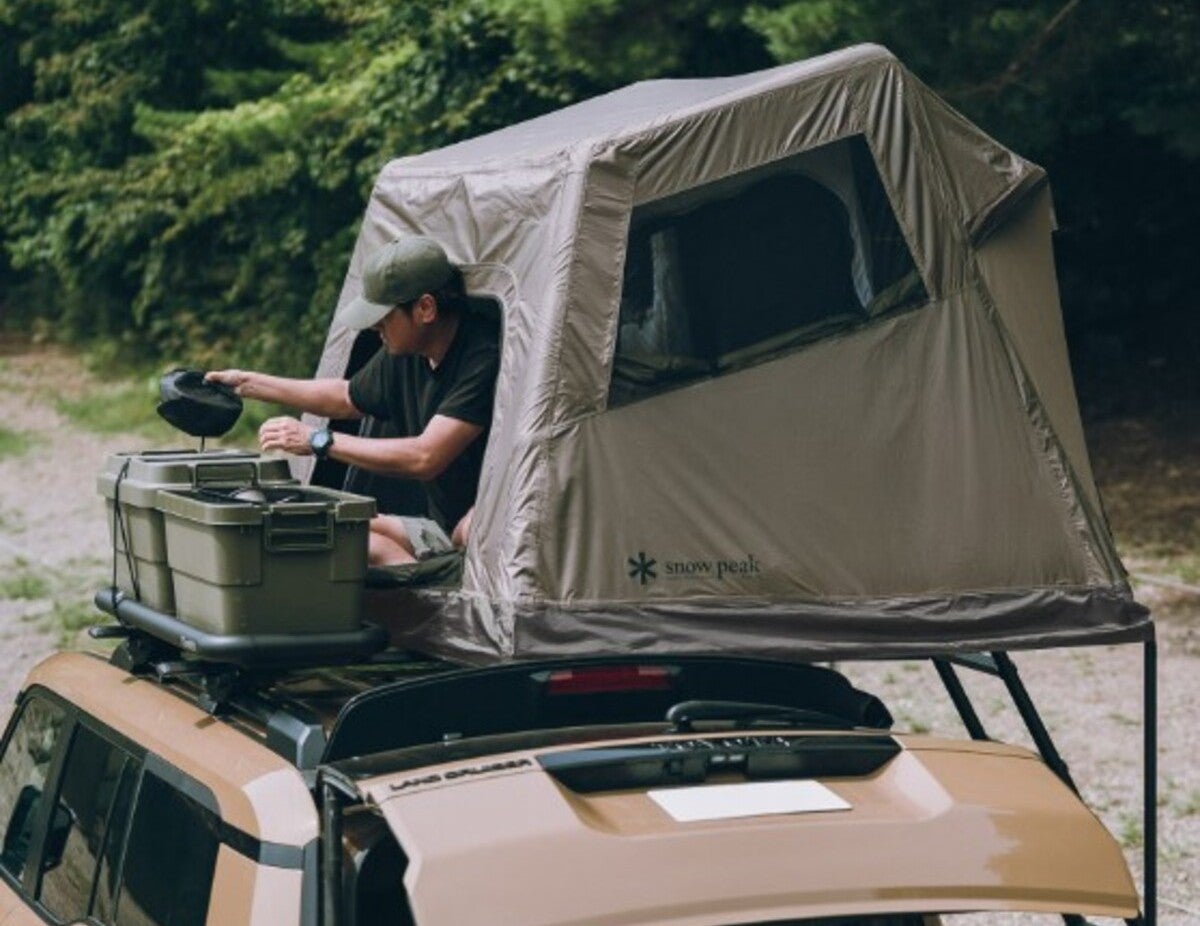 ルーフトップテントでくつろぐ男性