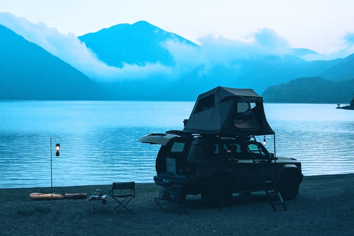 湖畔に駐車したルーフトップテント付きのSUV