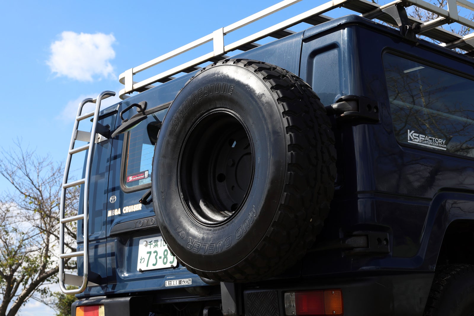 トヨタ・メガクルーザーのリアラダーとスペアタイヤ。旧車レンタカーで冒険気分