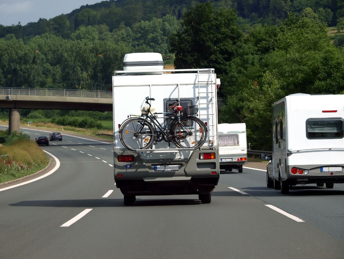 リアに自転車を積んで高速道路を走るキャンピングカー