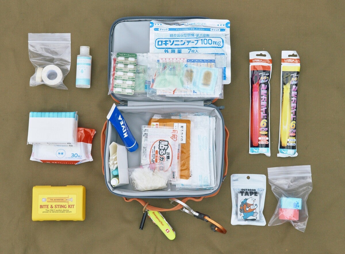 シートに並べた非常用持ち出しバッグの日用品の集合写真