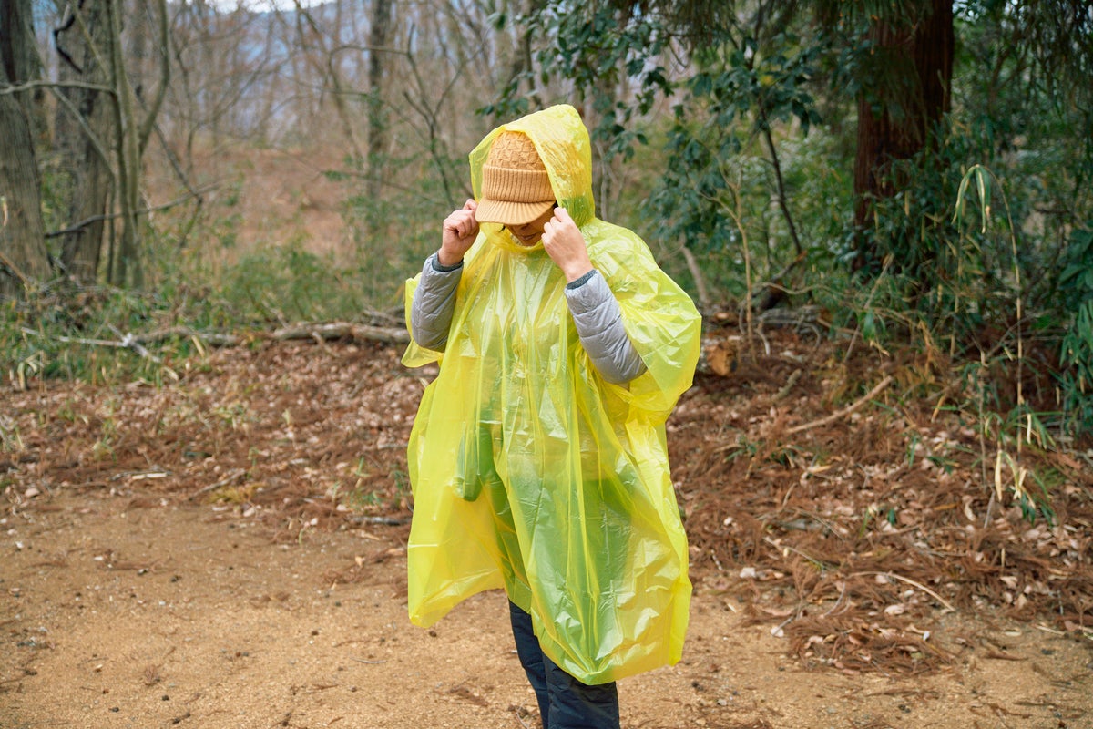 黄色いビニールポンチョを被る女性