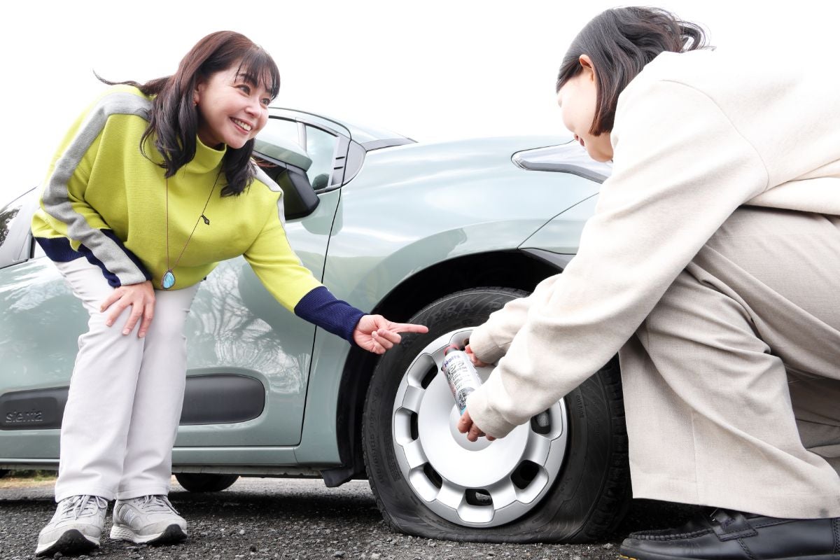 前輪タイヤに向かってホルツのパンク修理剤を使用している様子