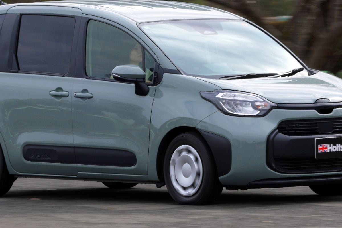 応急修理終了後、走行中のコンパクトカーの外観