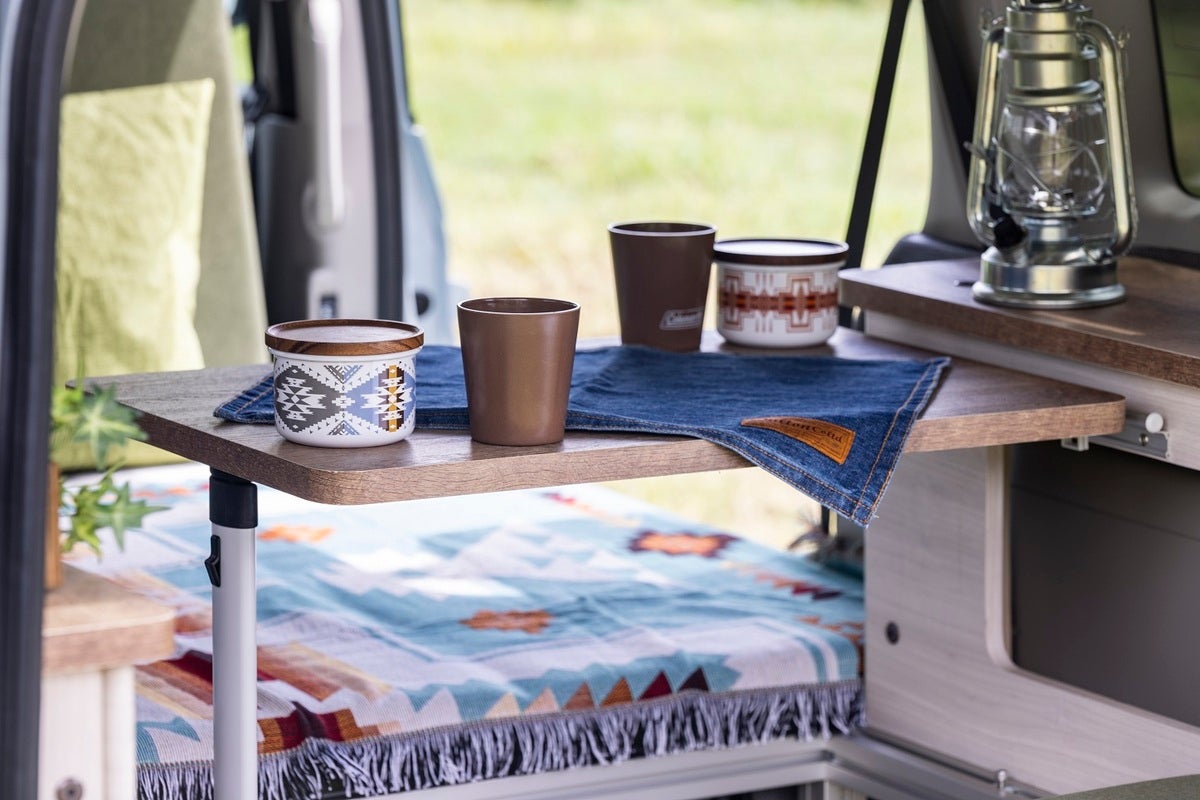 キャンピングカーの車内テーブルの上に食器を並べた風景