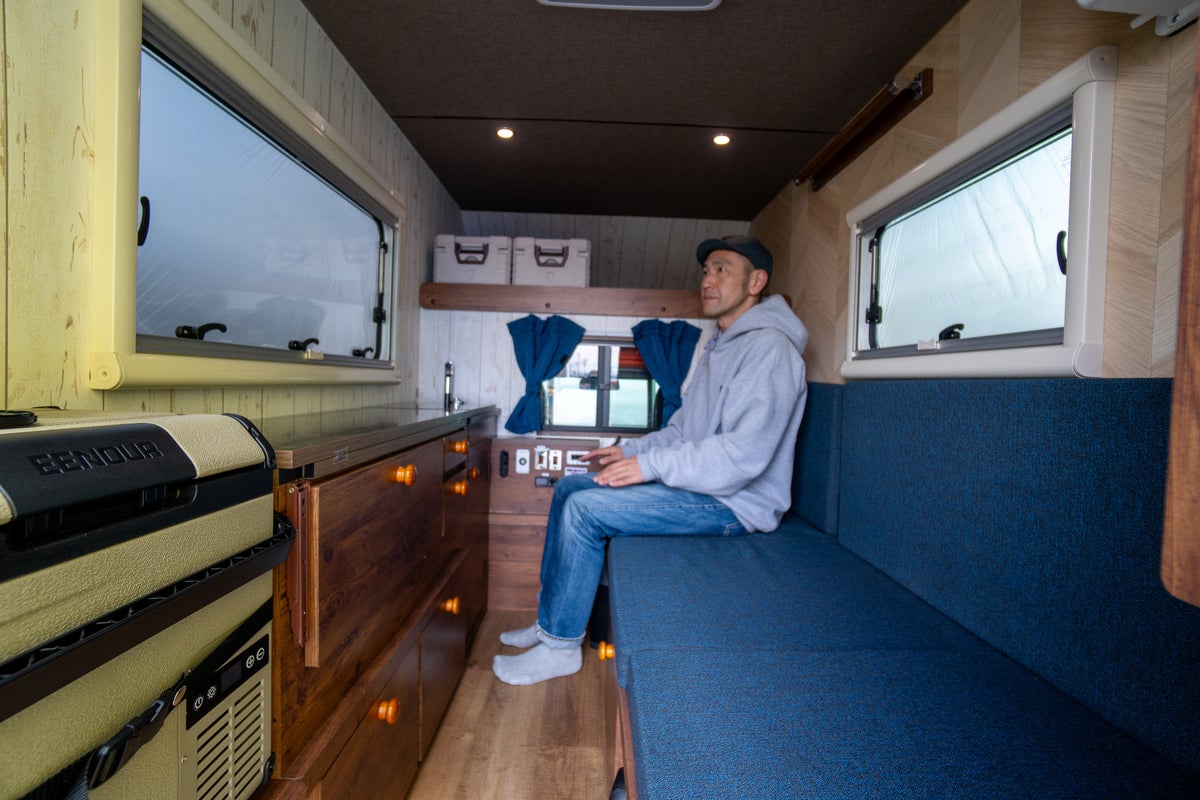 軽トラキャンの車内ベンチに腰かけている男性