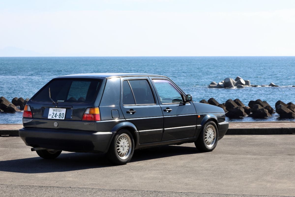 海岸沿いに停車するフォルクスワーゲン・ゴルフⅡのリアビュー
