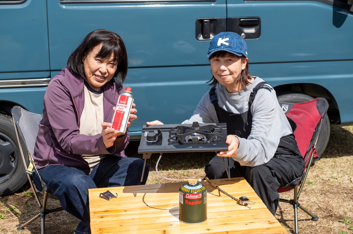コールマンのデュアルガスバーナーを手に持つ女性2名