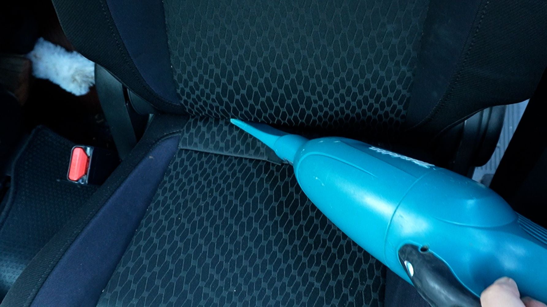 車内を掃除機で清掃する様子｜シートや足元のホコリ除去