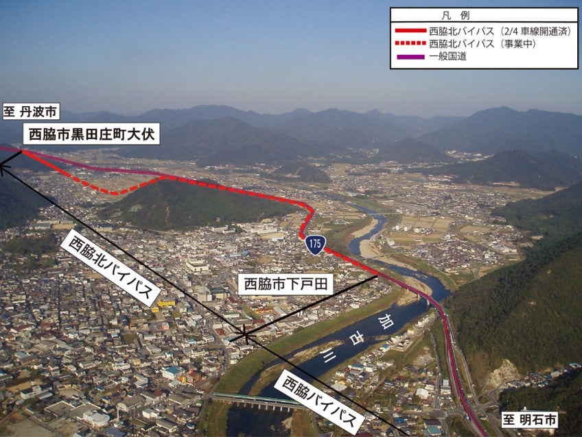 西脇市を上空から撮影した写真。加古川沿いに走る現道の国道175号と、市街地西側を迂回する西脇北バイパスのルートが重ねて示されている。赤実線が開通済区間、赤点線が今回開通する区間を示す。