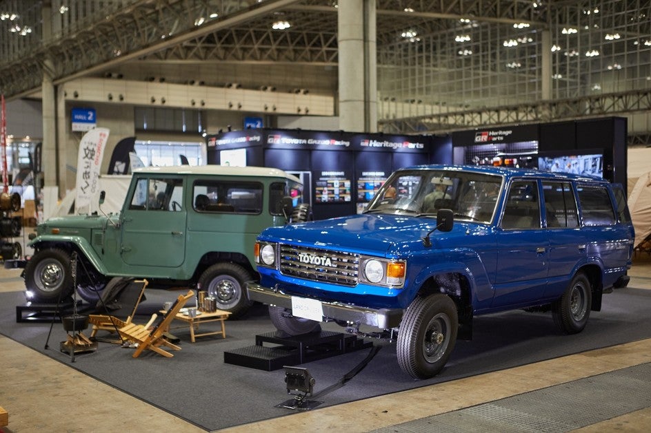 幕張メッセ会場内のToyota GAZOO Racing Heritage Partsブースに展示されたランドクルーザー2台。周囲にはアウトドアチェアなども配置されている