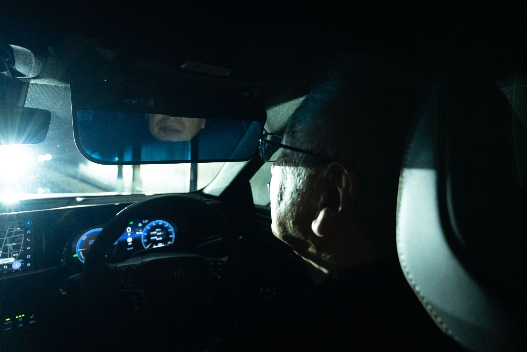 夜間走行を想定し、対向車の眩しいハイビームを調光サンバイザーで防眩している様子