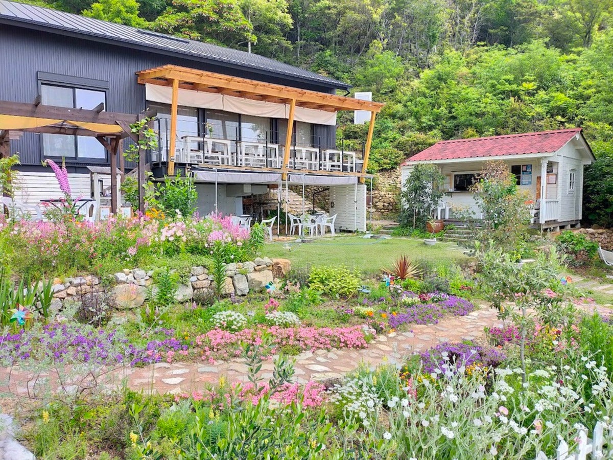 花畑の奥に見える木造の建物