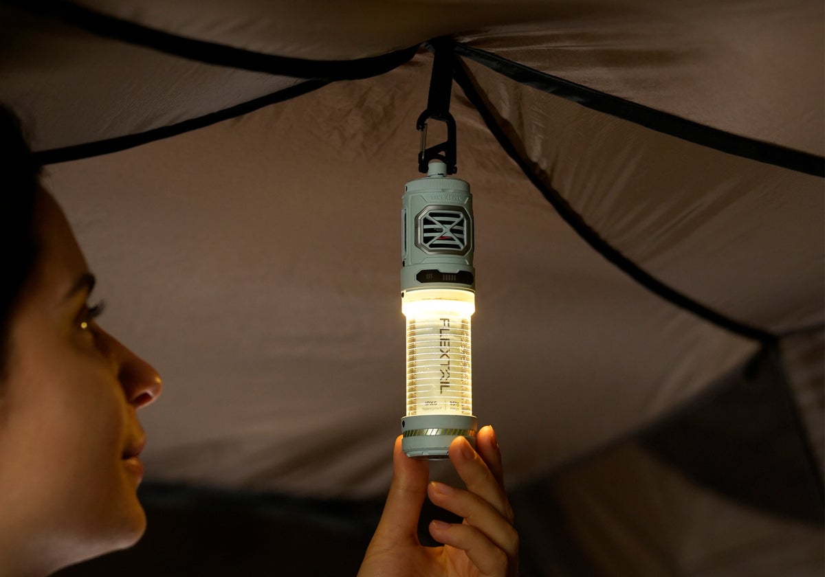 テント内で筒型LEDランタンの光を確認する人の横顔