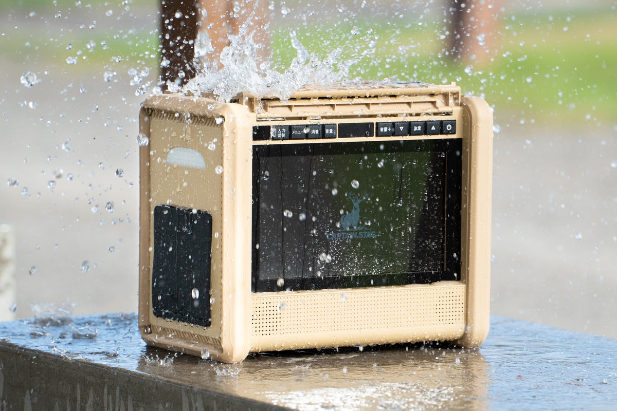 雨のアウトドアシーンでポータブルラジオを使用する様子