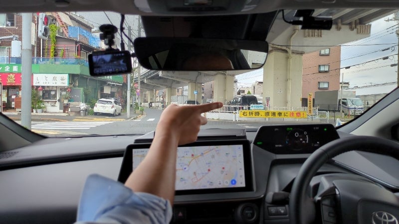 瑞江駅西通り高速下交差点を直進する取材車