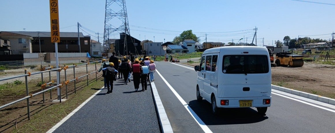 鴻巣市箕田地区の新設道路を走る車両と、幅2.5mの歩道を歩く人たちの様子